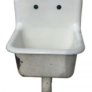 Standard utility sink, cast iron, white in color with integrated trap