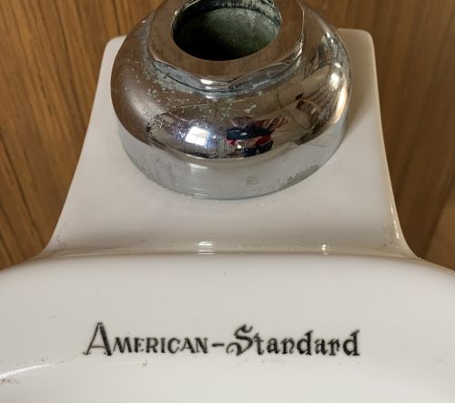 American Standard logo in front of spud on urinal