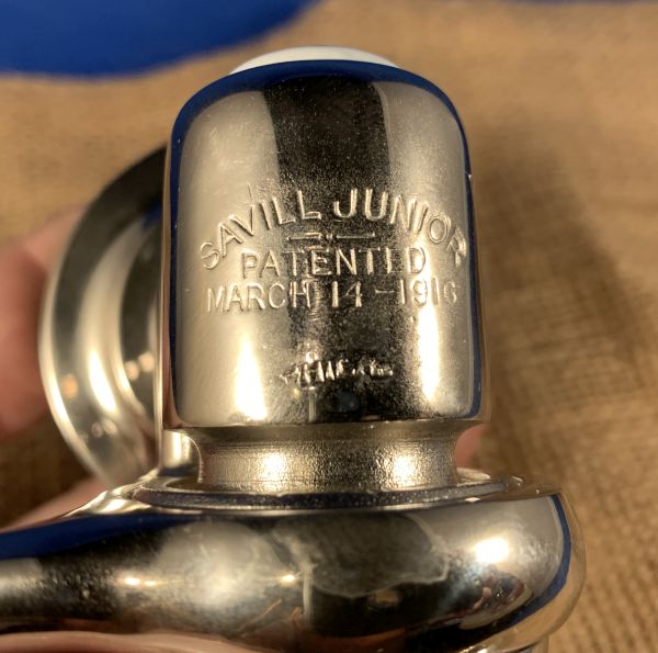 Logo saying Savill junior patented march 14th, 1916 of front of faucet